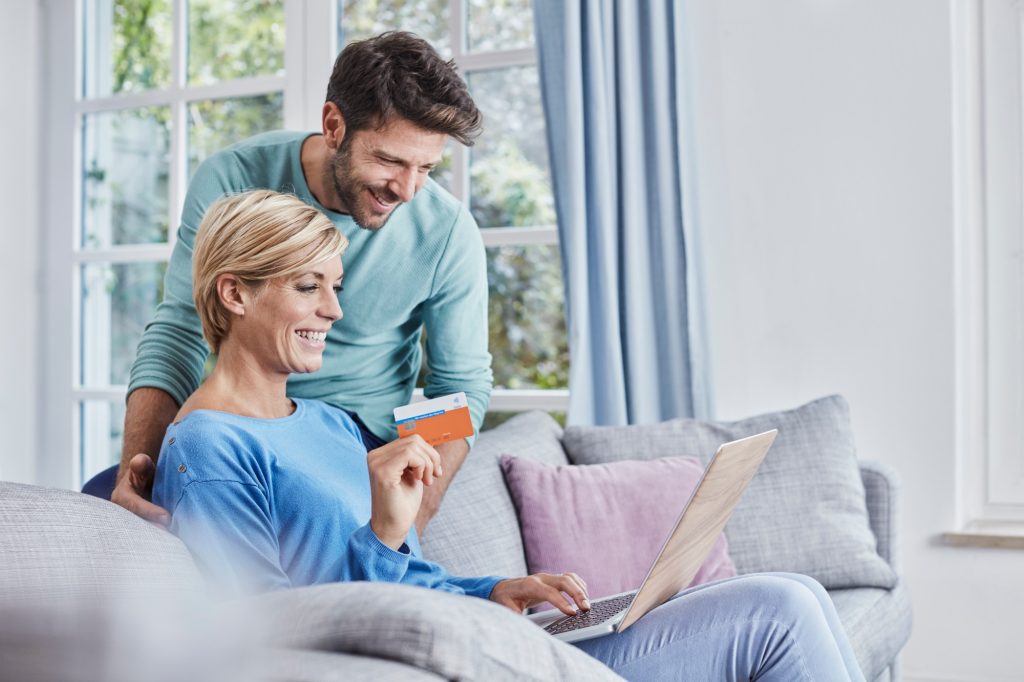 Happy couple at home shopping online